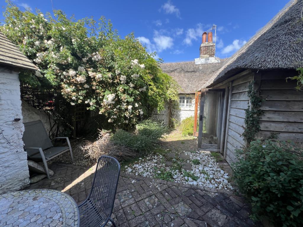 Lot: 138 - TWO-BEDROOM THATCHED COTTAGE FOR OCCUPATION OR INVESTMENT - Cottage with garden and flowers